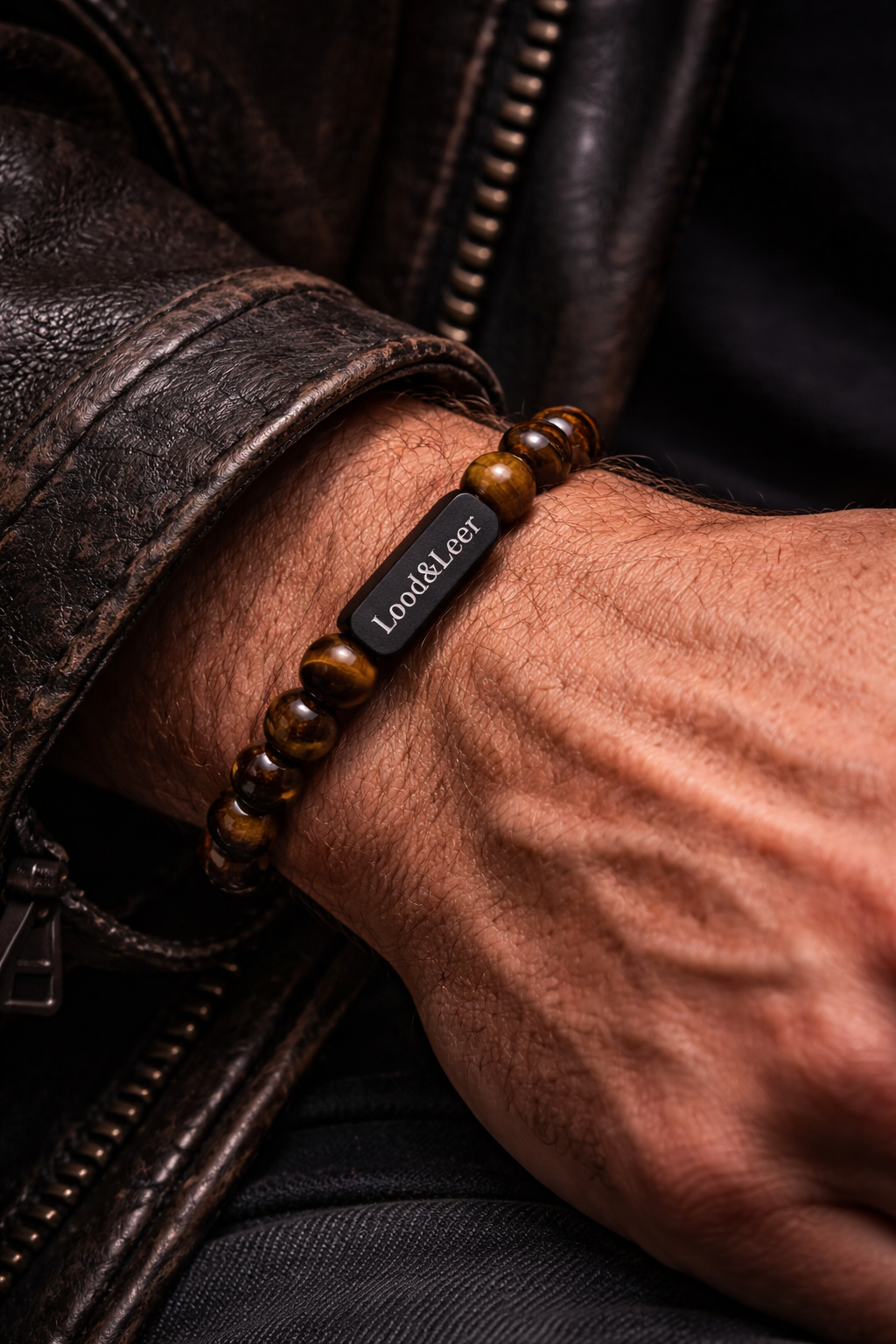 Tijgeroog armband gedragen om de pols met leren jas